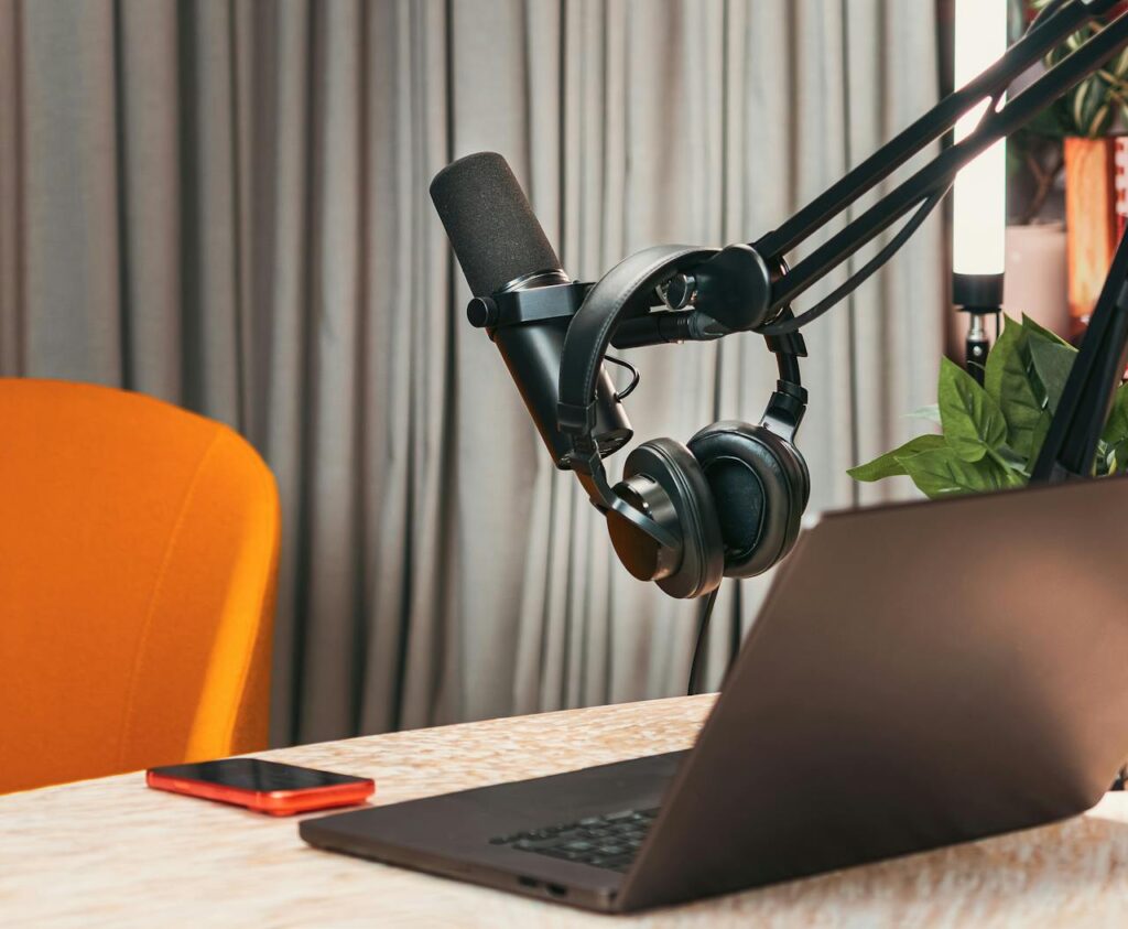 pexels photo 37033739 Modern podcasting studio with mic, headphones, laptop, and smartphone on a wooden table.